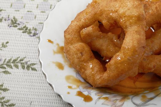 Traditional peruvian dessert Picarones. Made of sweet potato, pumpkin and wheat flour. Fried an served whit honey figs.