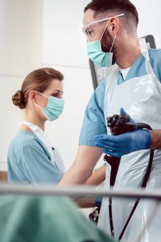 Team of doctors performing endoscopy in hospital examining stomach of patient