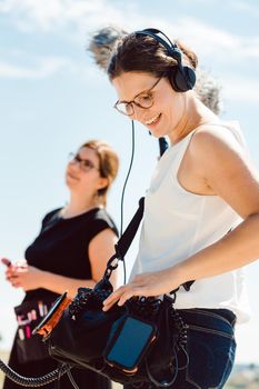 Sound engineer with microphone on a video production set operating her gear