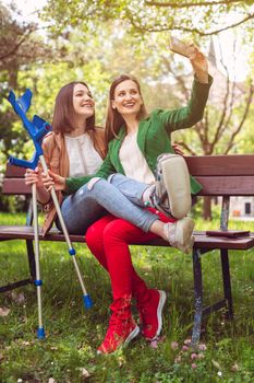 Woman and her friend with a sprained ankle taking a photo or selfie