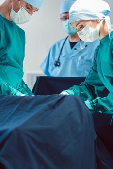 Doctors and surgeons operating patient in hospital with full concentration