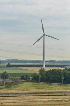 Windmills as wind turbine power generators placed within the countryside of green country of Netherlands.