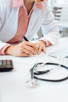 Doctor writing prescription on her desk