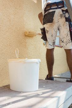 Torso of man painting a wall on construction site working