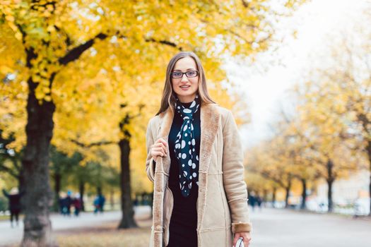 Beautiful woman in autumn with colorful trees in the background