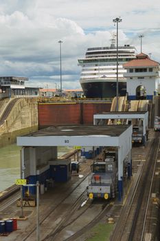 Cruise ship going through locks in Panama Canal. Vertical image with cloudy sky in the background