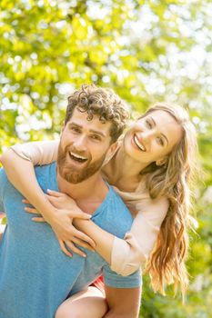 Husband is carrying his wife on his back being a strong and reliable partner