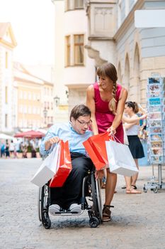 Handicapped man and his friend shopping in town showing each other what they have bought