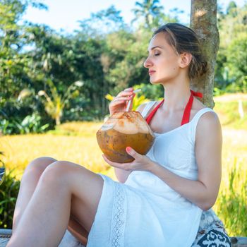 Woman relaxing in her tropical vacation sitting in the jungle looking at the scenery