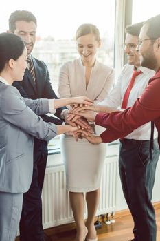 Diversity team of business people in kick-off meeting stacking hands together