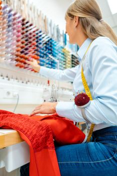 Close-up on the hand and works of an alterations tailor at her sewing machine