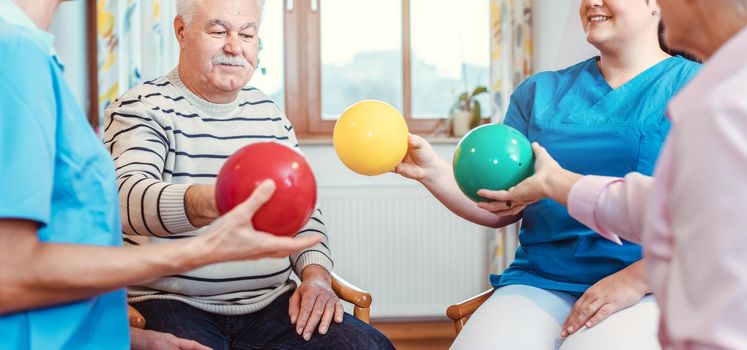 Group of seniors doing sport and gymnastics with balls in the pensioners home