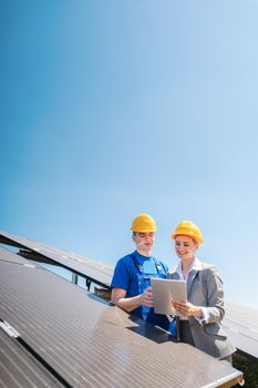 Manager and worker in photovoltaic power plant discussing maintenance of the solar farm