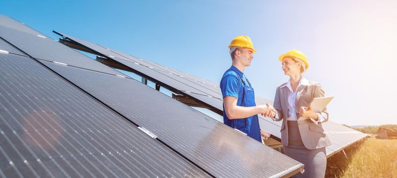 Construction worker and investor in solar power plant shaking hands after completion of the project