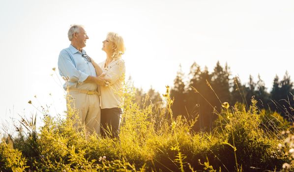 Senior woman and man hugging still being in love in a romantic setting