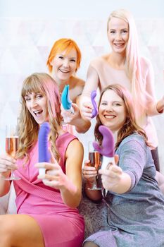 Women showing sex toys they bought at a dildo party and drinking champagne