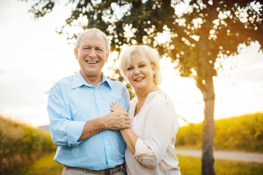 Senior couple hugging each other outdoors during sunset