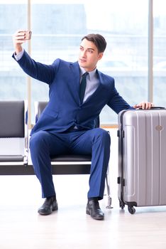Businessman waiting at the airport for his plane in business class
