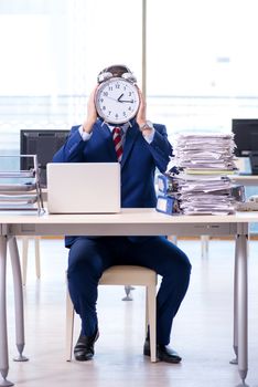 Businessman employee in urgency and deadline concept with alarm clock