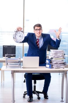 Businessman employee in urgency and deadline concept with alarm clock