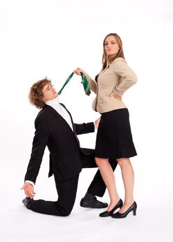 Business people - he is kneeling in front of her and she is pulling him on this tie