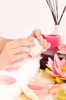 Woman takes care about her nails and putting cream on her hands