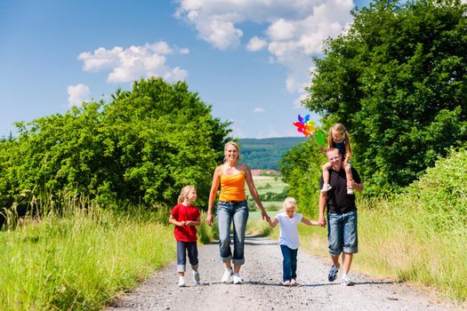 Family walking down a rural path on bright summer day