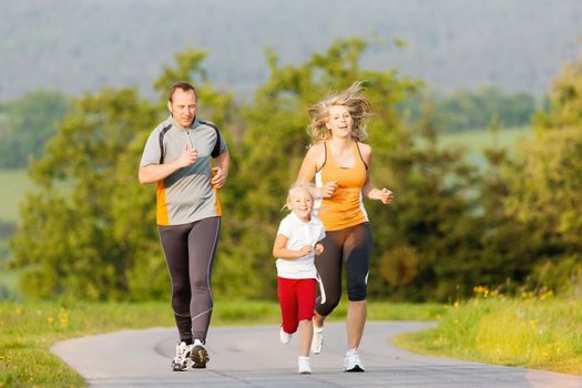 Family jogging for sport for fitness outdoors with the kids