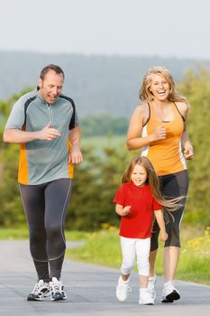 Family jogging for sport for fitness outdoors with the kids