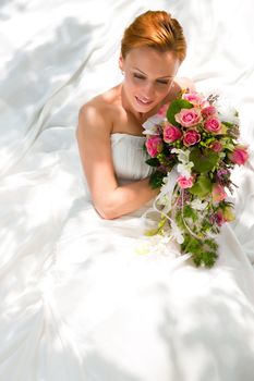 Bride sitting holding a bouquet of flowers in her hand