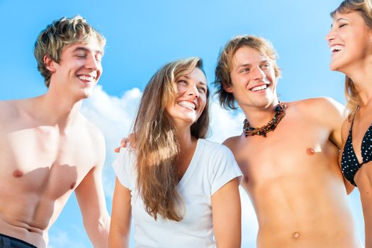 Group of four very beautiful people - men and women - on the beach