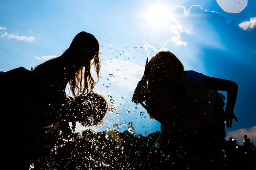 People feeling free in the sunset having a summer party in the water