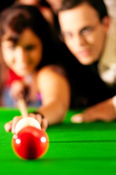 Couple (man and woman) in a billiard hall playing snooker