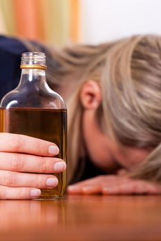 Woman sitting at home drinking way too much brandy, she is addicted