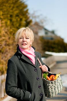 Woman with her groceries standing on the street