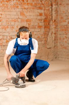 Construction worker working grinding the cement floor