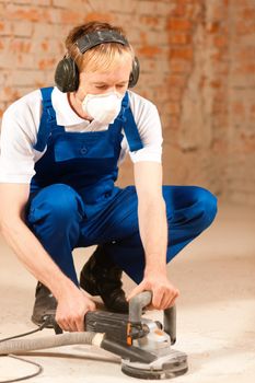 Construction worker working grinding the cement floor