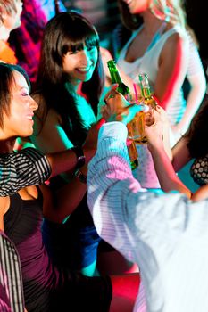 Dance action in a disco club - group of people, men and women of different ethnicity, dancing to the music having lots of fun