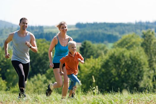 Active Family jogging outdoors in beautiful summer landscape 