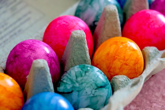 Beautiful colored eggs in a cardboard box