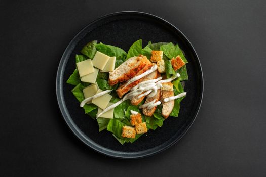 Caesar salad in heart shape love food concept, black stone luxury plate, top view flat lay design, black background