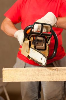 Construction worker with motor saw doing some renovation