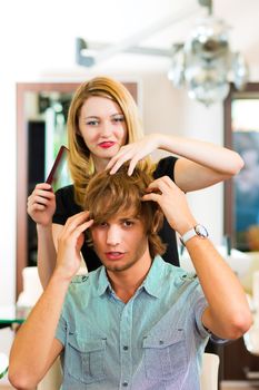 Man at the hairdresser, she is cutting his hair