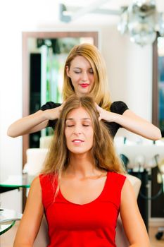 Woman at the hairdresser getting a head massage in the salon