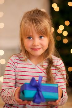 Girl in front of a Christmas tree with presents