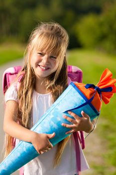 Proud kid having first day at school holding a traditional cone filled with sweet stuff