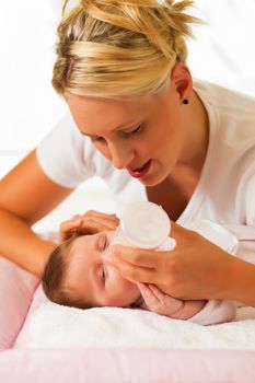 Mother is feeding her baby with a bottle; very tranquil scene