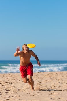 Man on the beach playing Frisbee