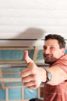 Man doing dry walling, working under a roof slope