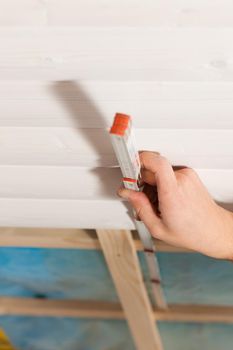 Man doing dry walling, working with a folding rule